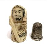A Japanese carved and stained bone figure of a warrior, height 5cm; together with a silver