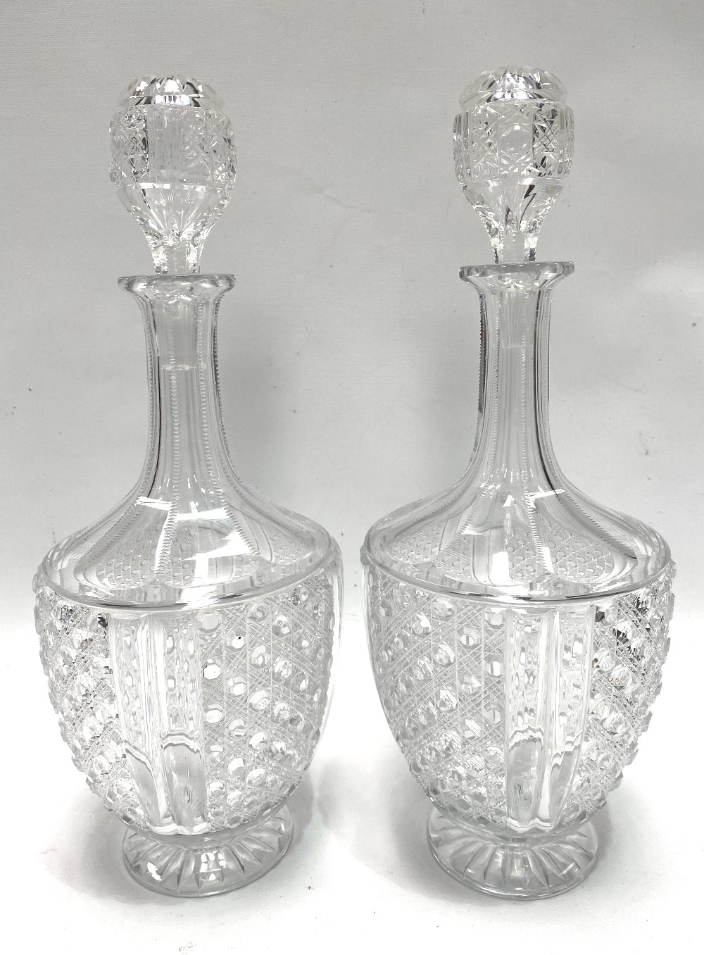 A pair of cut glass pedestal decanters and stoppers, height 33cm.