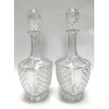 A pair of cut glass pedestal decanters and stoppers, height 33cm.