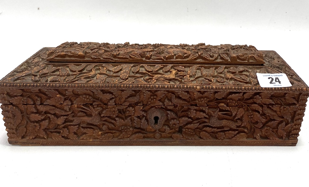 An Indian carved teak rectangular hinge lidded stationery box, with caddy top, the whole profusely