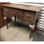 Antique oak lowboy, the top with re-entrant corners over three drawers and a shaped apron and four