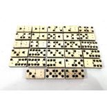 A set of twenty eight antique bone, ebony and brass dominos with brass pins.