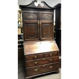 18th Century oak bureau cabinet, the raised back with swan neck pediments and brass applied