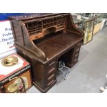 Early 20th Century mahogany tambour roll top twin pedestal desk enclosing pigeonholes and drawers,