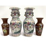 A pair of Chinese famille rose vases decorated with reserves of figures, with Fo dog lug handles,