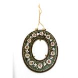 An oval micromosaic frame with floral decoration upon lacquered brass, the aperture 35 x 28mm.