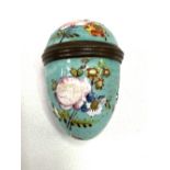 A rare 18th century enamel egg shaped nutmeg grater, painted with floral sprays upon a pale blue
