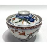 A Chinese Wucai bowl and cover decorated with rocks issuing foliage, the lid and bowl with four