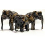 A pair of 19th century Chinese black lacquer gilt painted opposing elephants, decorated with figures