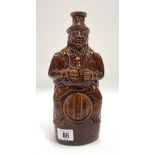 A Victorian treacle glaze whisky flask moulded as a portly gentleman seated on a barrel, height 24cm