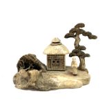 Chinese carved bone ornament modelled as a building with figure under a tree, width 7cm.