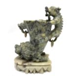 A Chinese soapstone libation cup on stand with dragon handle and lion masks, height 17cm.
