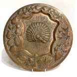 Two Indian copper embossed circular wall plaques; together with a silvered Indian wall plaque,