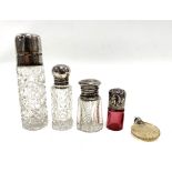 Five various silver lidded scent bottles.