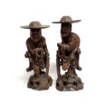 A pair of oriental opposing root carved sage figures wearing hats, height 38cm.