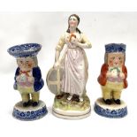 A 19th century Staffordshire Pottery figure modelled as a lady holding a book and with a shield by