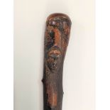 An Irish blackthorn walking cane, two carved faces to the knop, length 89.5cm.