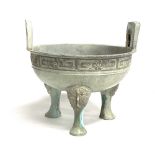 Chinese bronze twin handled archaic design bowl raised on three feet, width 26cm