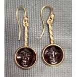 Good pair of gold garnet set drop earrings, the circular garnets carved with man on the moon face,