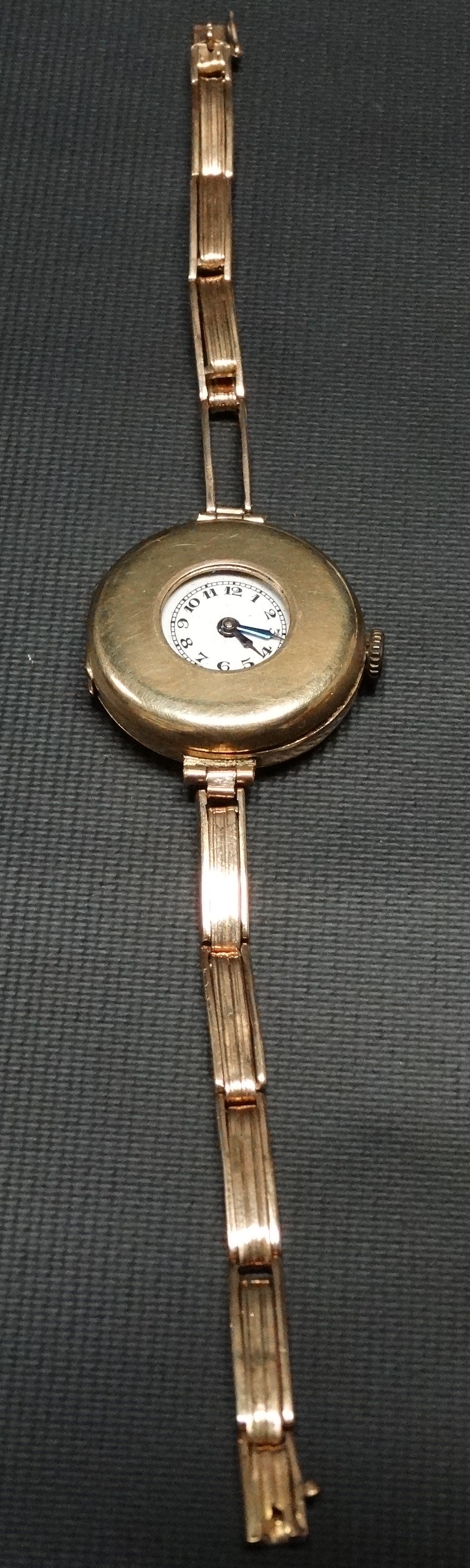 A 1920's 18ct gold cased half hunter ladies manual wind wristwatch, the 21mm white enamel dial