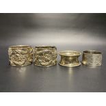 Pair of Victorian silver heavy foliate scroll cast napkin rings, London 1896; together with two