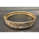 Italian 9ct gold hinged bangle with engraved foliate scroll textured design, stamped Italy 75,