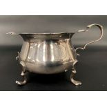 Victorian silver sugar bowl with pie crust rim and raised on four feet and with singular handle (