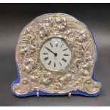 Modern silver mounted timepiece embossed with cherubs and fruiting vine with a quartz timepiece,