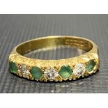 A 18ct hallmarked gold diamond and emerald seven stone set half eternity ring, the three diamonds