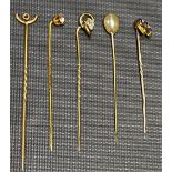 Five yellow metal stick pins, weight 4.3g approx.