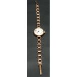 A 9ct hallmarked gold ladies manual wind bracelet wristwatch, the 16mm white dial with gilt Arabic