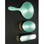 George V silver child's green guilloche enamel three piece dressing table set comprising hand mirror