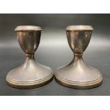 A pair of modern silver squat candlesticks with weighted bases.
