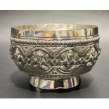 Indian white metal embossed bowl decorated with a band of seated immortals, the base stamped D.K