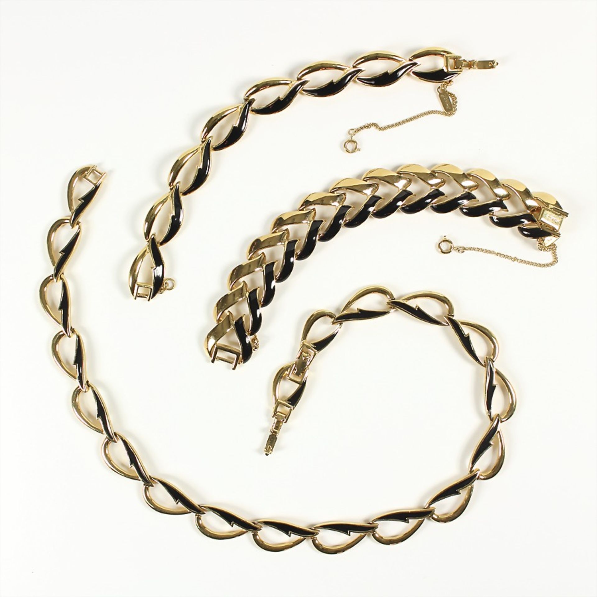 lot: 1 necklace and 2 bracelets with folding clasps, gold colored, signed: "MONET", black enamel