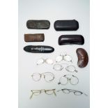 A collection of 8 circa 1900 eyeglasses, some with cases.