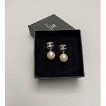 CHANEL - PAIRE DE BOUCLES D'OREILLES en métal argenté, serties d'une perle [...]