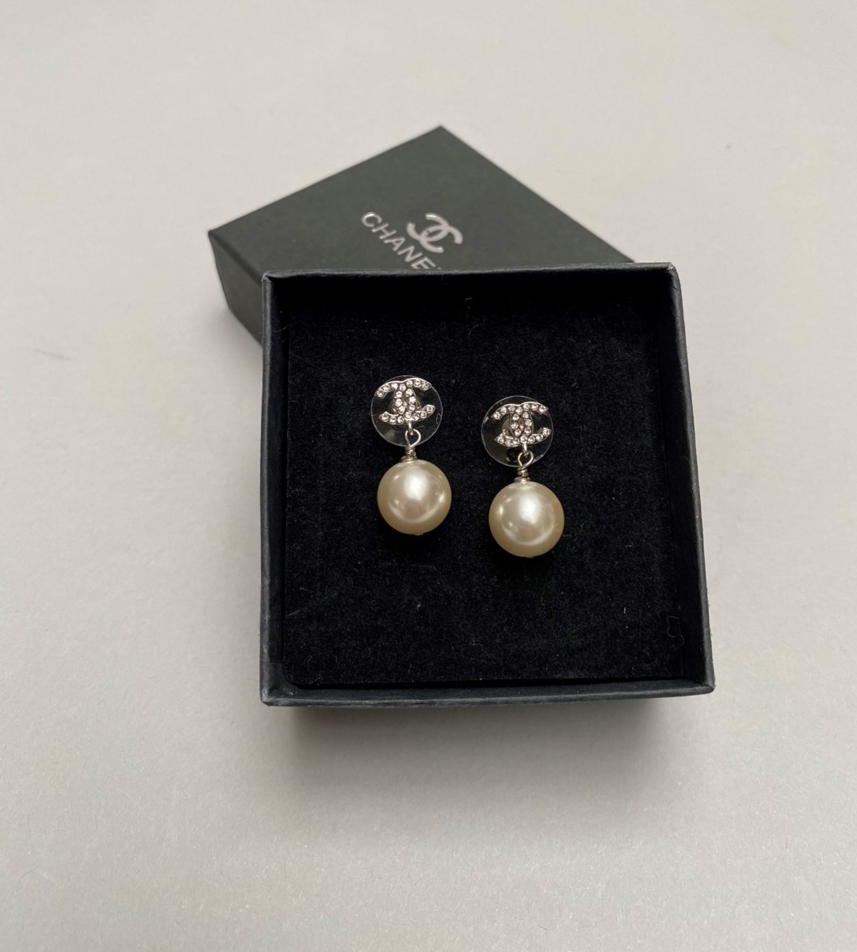CHANEL - PAIRE DE BOUCLES D'OREILLES en métal argenté, serties d'une perle [...]