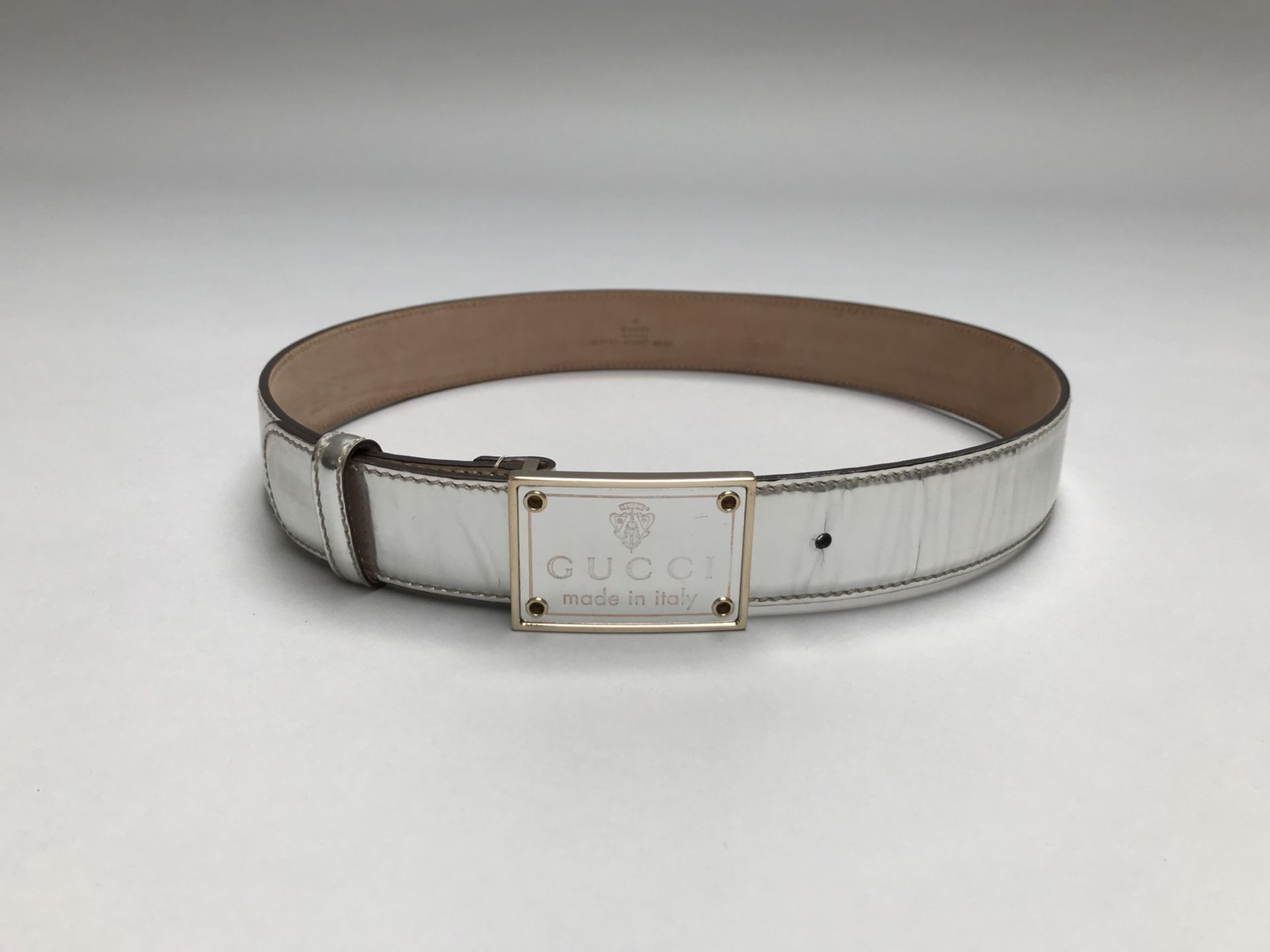 GUCCI- MADE IN TALY - CEINTURE en cuir argenté et métal doré.. Signé. T.80. - [...]