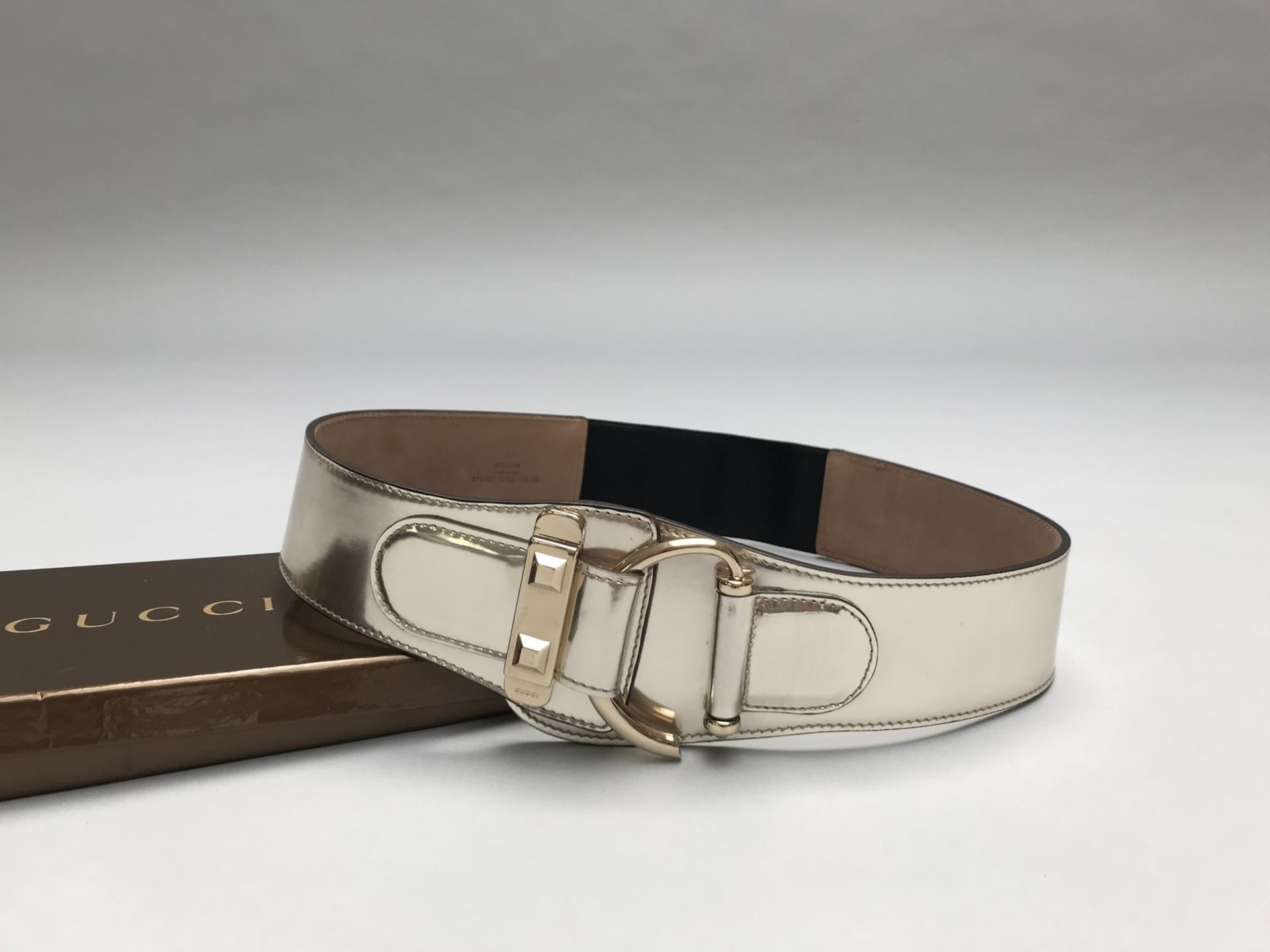 GUCCI- MADE IN TALY - CEINTURE en cuir argenté et métal doré. Elastique au dos. [...]