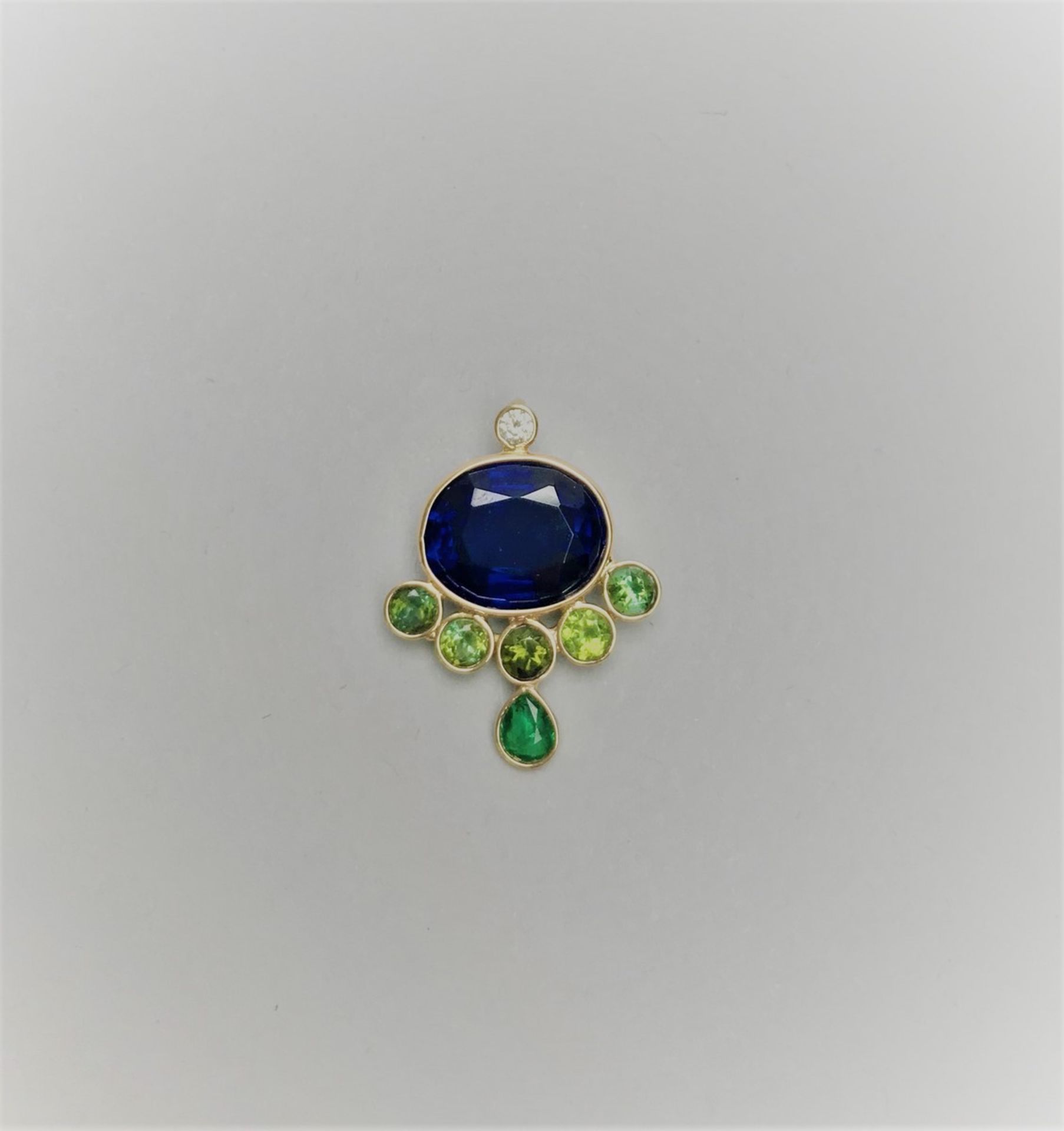 PENDENTIF en or serti d'un saphir de Ceylan, péridots et un diamant taille brillant. [...]