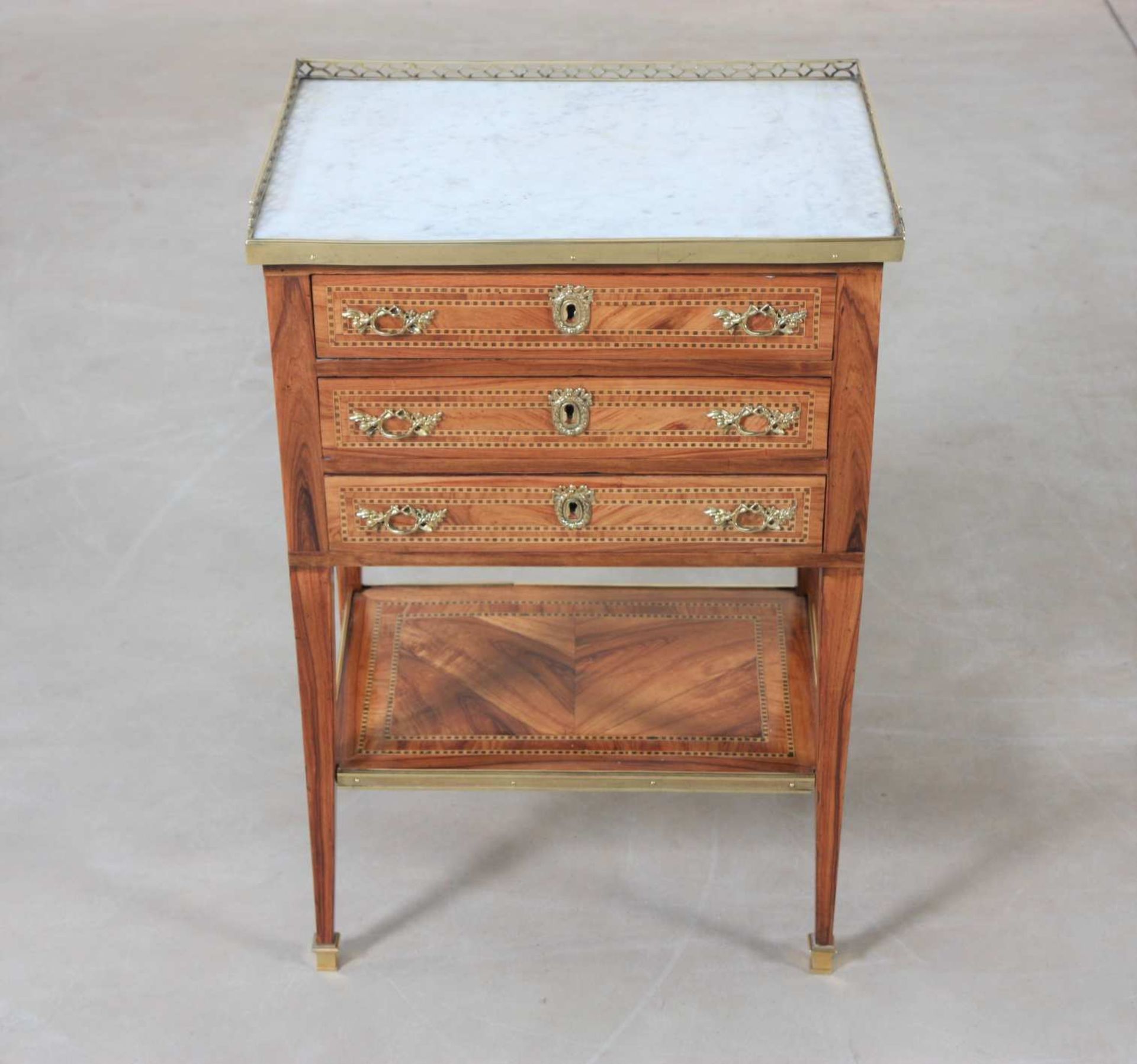 Petite table de salon marquetée Louis XVIEn marqueterie toutes faces de bois précieux encadrée de