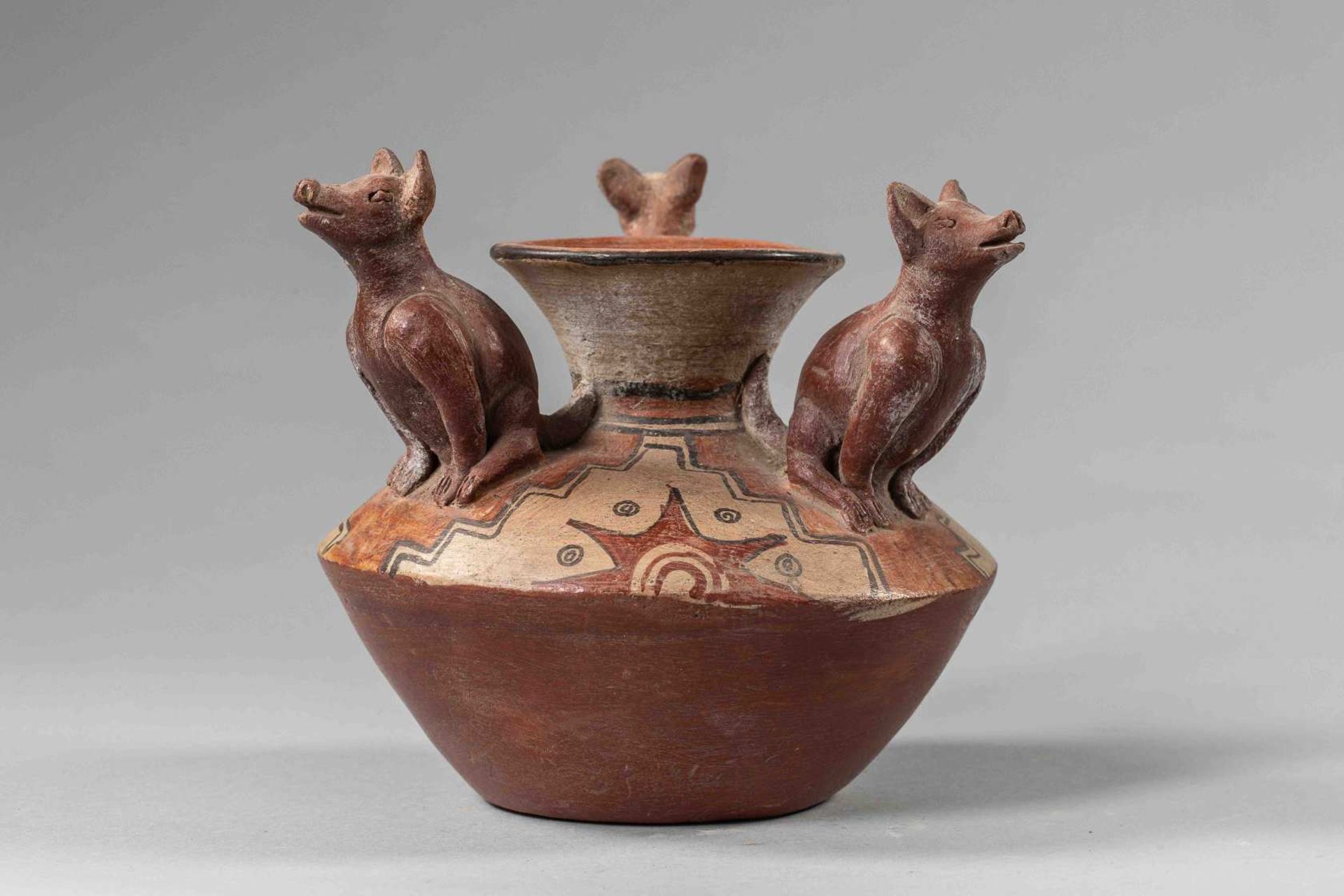 Vase - PérouEn terre cuite vernissée en trois tonalités ocre, vase serti de trois coyotes à l'