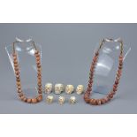 Two graduated agate beaded necklaces together with seven resin modeled skull beads. Skulls 2cm-3.5cm
