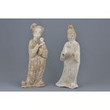 Two Chinese Tang dynasty white pottery painted figures of a man and lady holding a baby. Figure of t