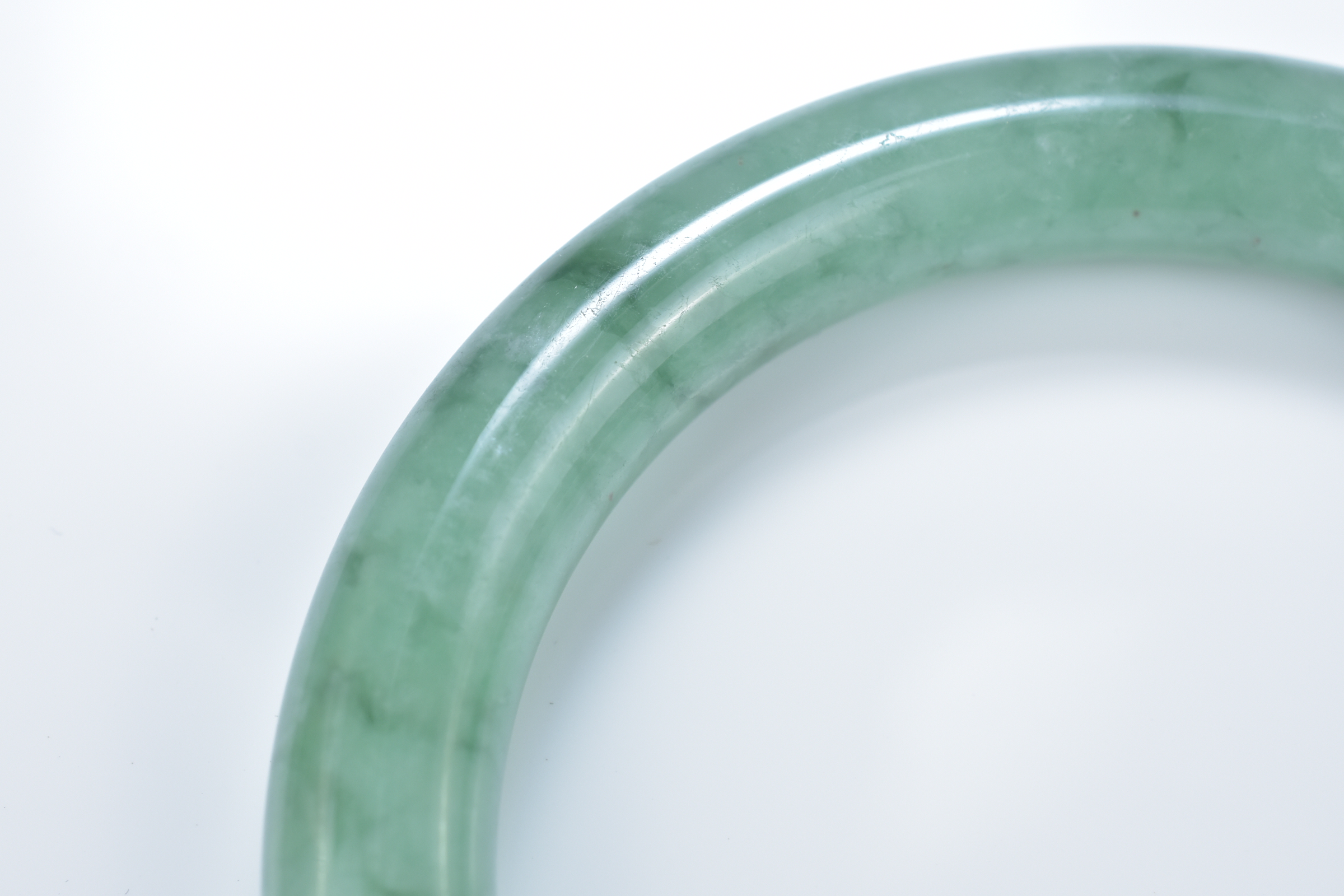 A Chinese pale and green jadeite bangle. 6cm inner diameter - Image 3 of 4