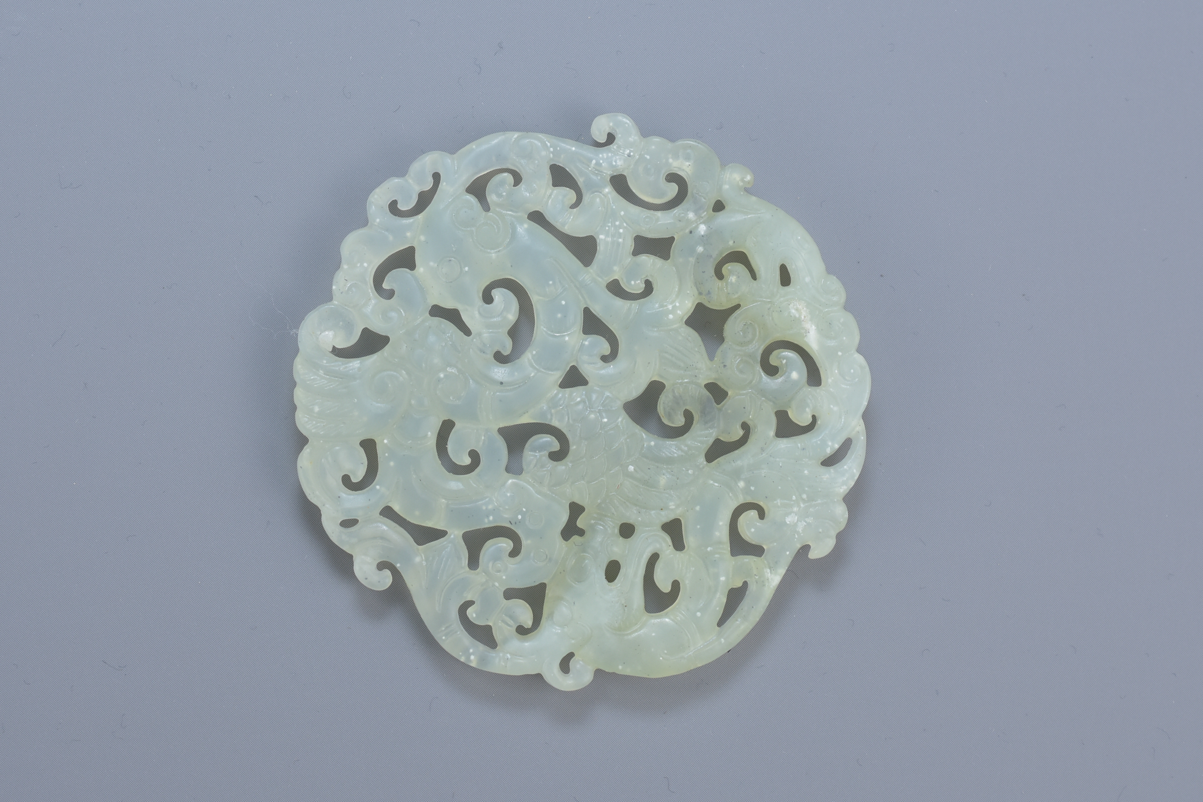 A Chinese carved jade pendant depicting a dragon and phoenix. 6cm diameter - Image 2 of 2