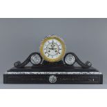 A very large Victorian black slate mantle clock with visible escapement and two train movement. With