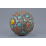 A large Tibetan decorative ball with hammered white metal, turquoise, coral and amber coloured stone