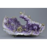 A large open natural amethyst rock crystal ornament with scene of pewter figures 'mining gold'. 36cm